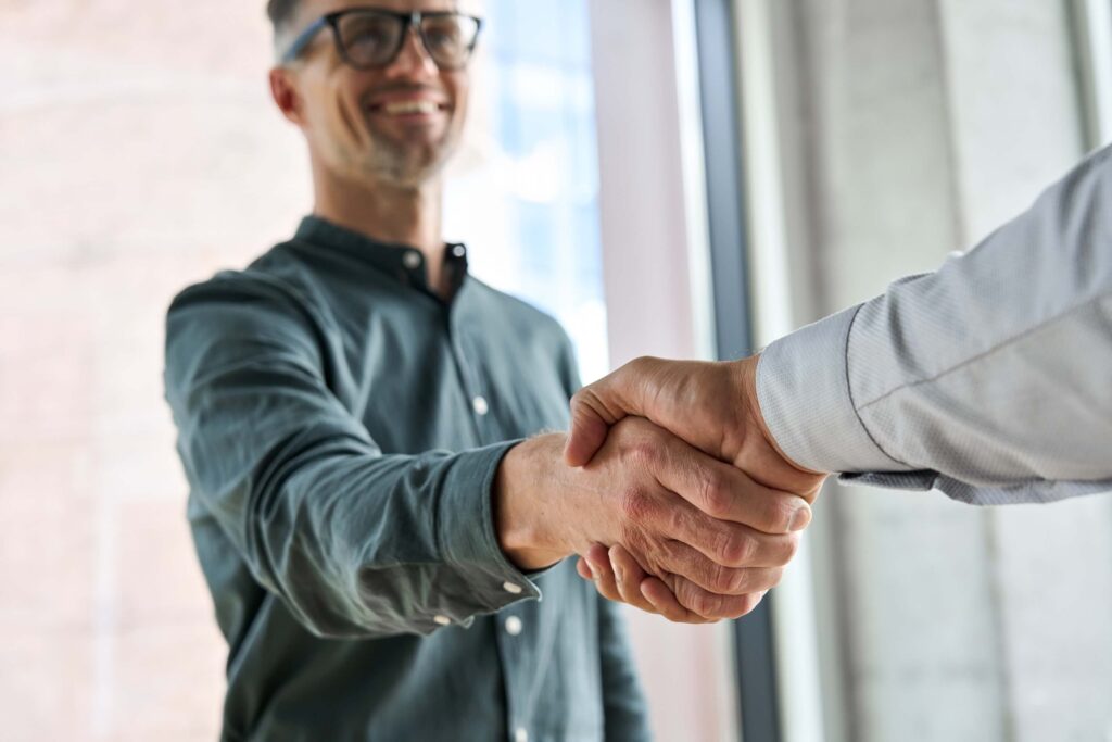 Two happy and diverse business leaders and executives shake hands 