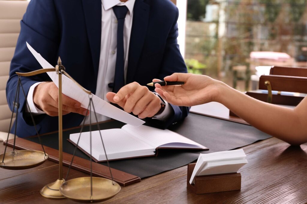 Lawyer working with client at table, concentrating on hands