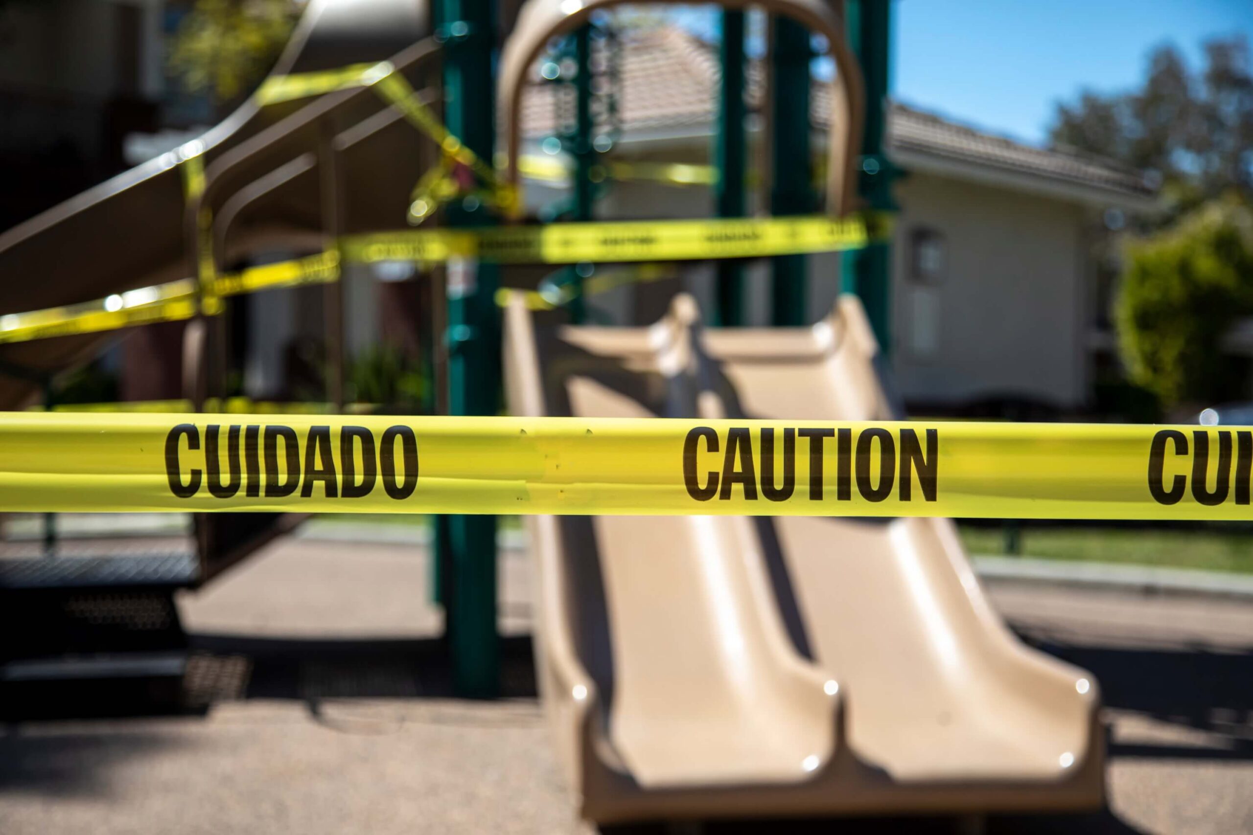 Caution tape in English and Spanish prevents access to playground